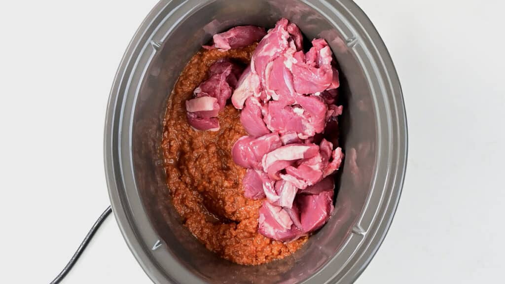 Diced lamb and curry paste in a slow cooker