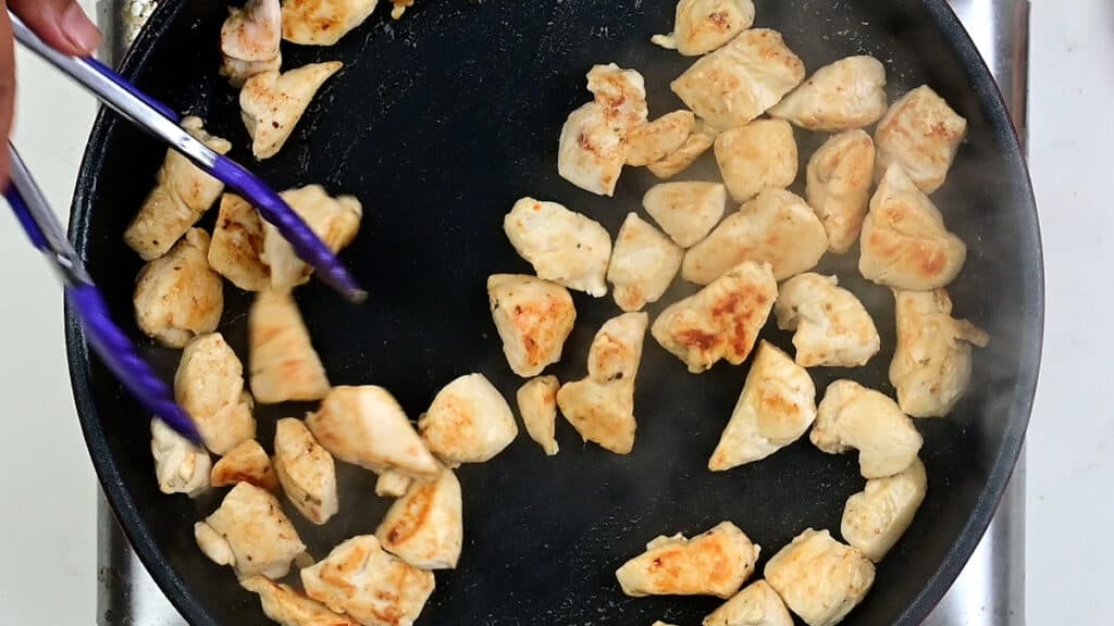 Pan frying diced chicken in a skillet