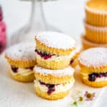 Victoria sponge cupcakes filled with whipped cream and jam on a ceramic board