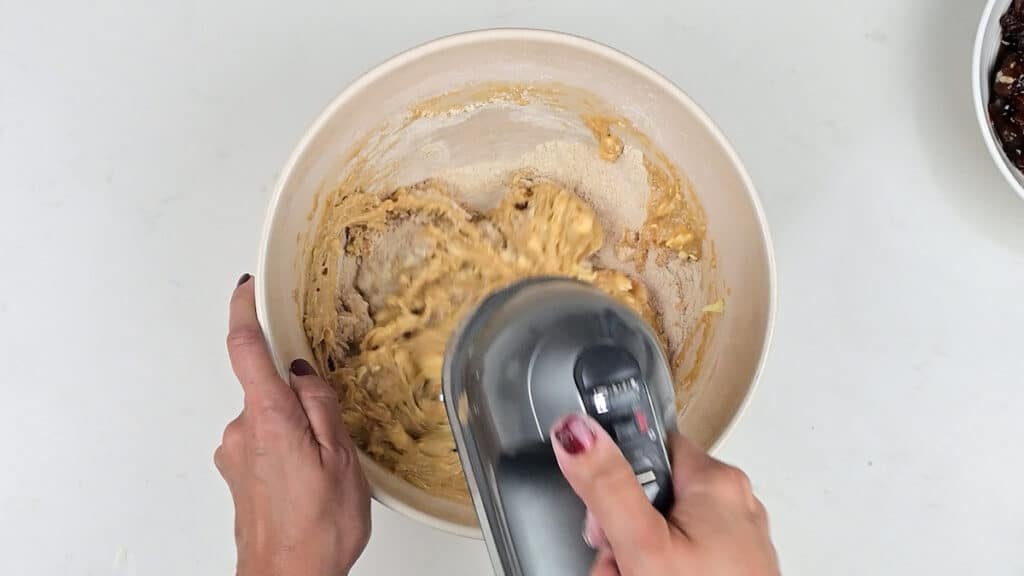 beating batter for Christmas cake with an electric hand mixer