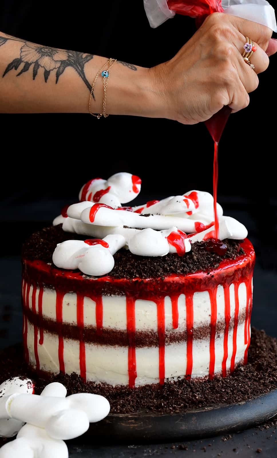 drizzling a spooky halloween cake with edible fake blood