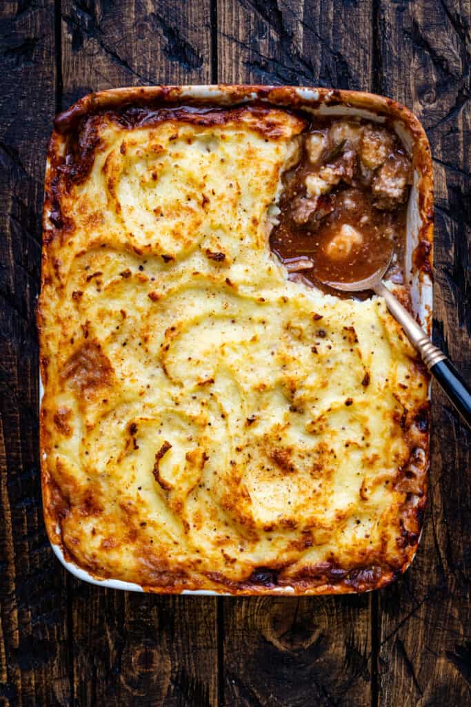 sausage pie topped with mashed potatoes in ceramic oven dish