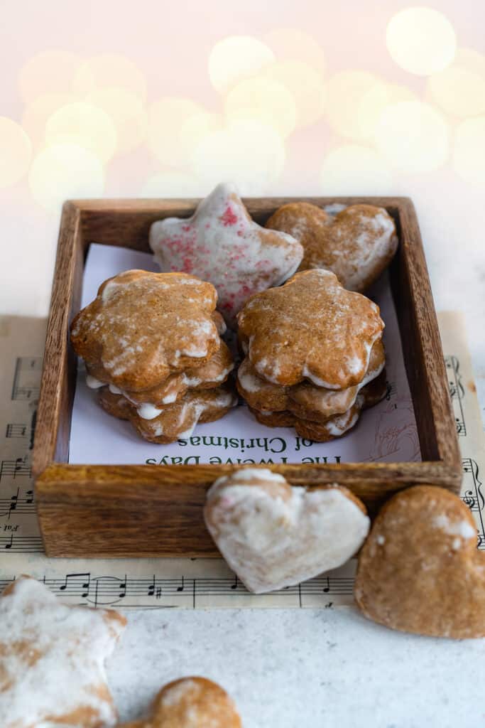Lebkuchen cookies in a small wooden box with Christmas lights in background