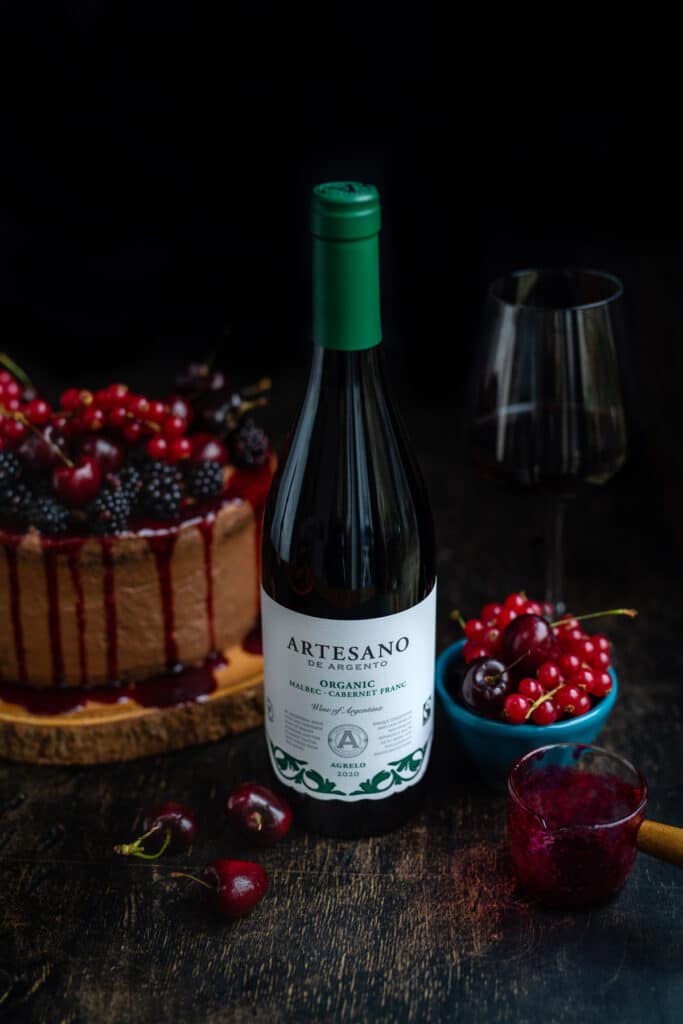 Bottle of red with with chocolate cake in background