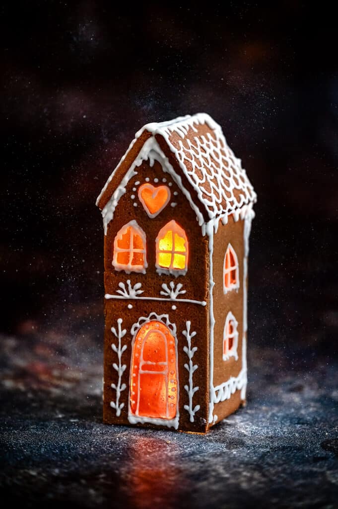 Tall and narrow gingerbread house against a dark backdrop