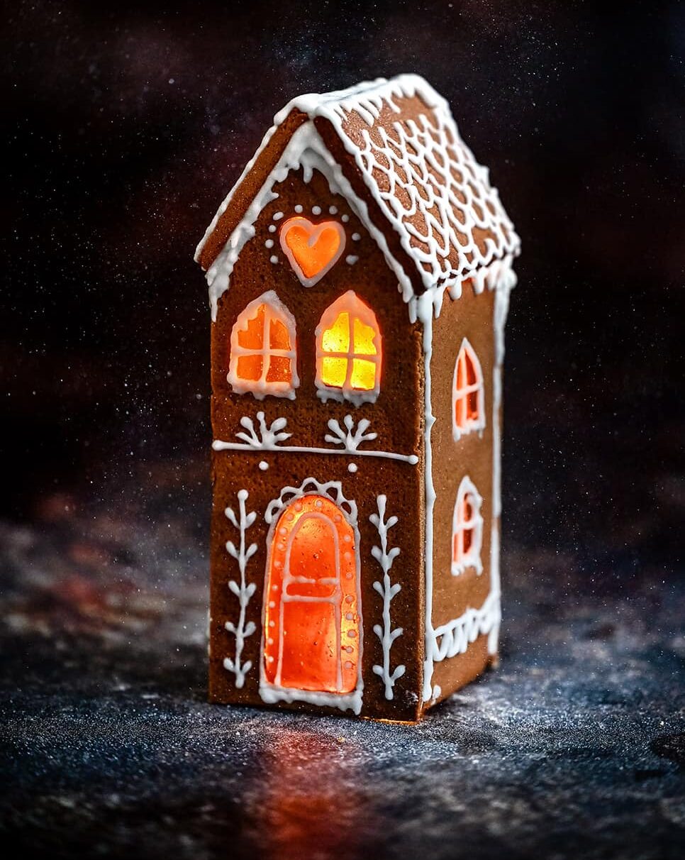 Tall and narrow gingerbread house against a dark backdrop