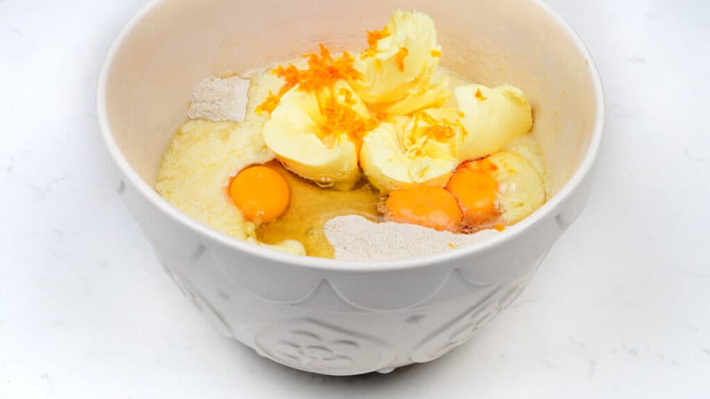 Eggs, butter, sugar, flour and orange zest in a mixing bowl