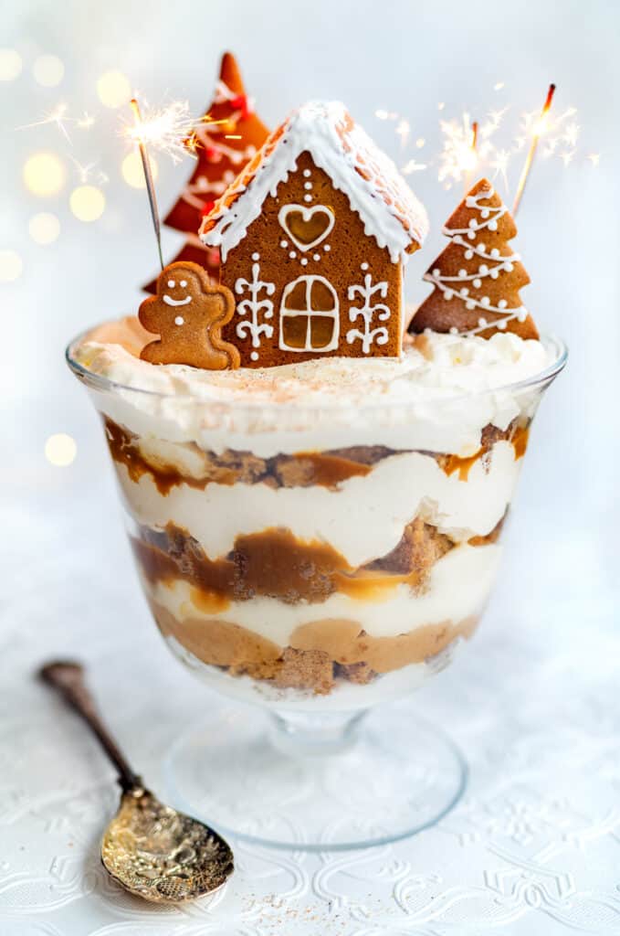 Gingerbread trifle decorated with a gingerbread house and cookies