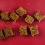 cubes of ginger cake on a red cutting board