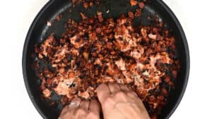 adding sausage meat to stuffing in a skillet