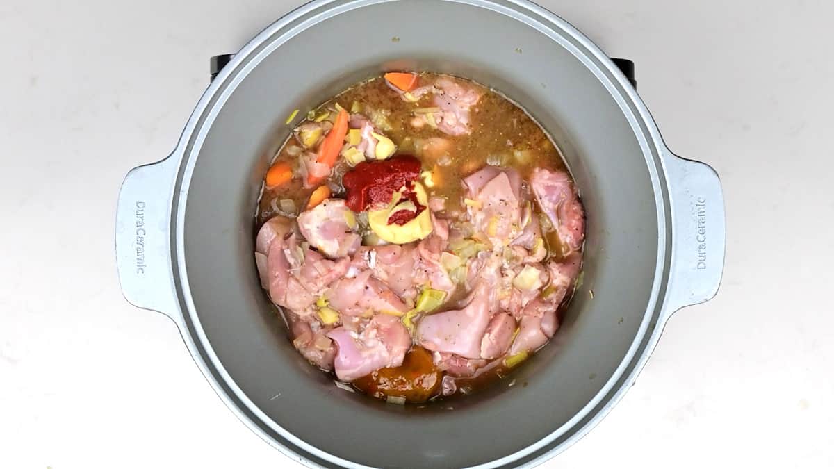 Overhead photo of chicken stew and meatballs in a ceramic pot