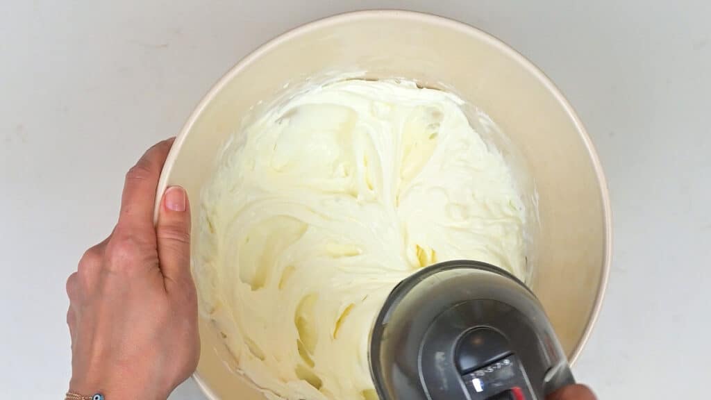 Beating mascarpone and cream with an electric hand mixer
