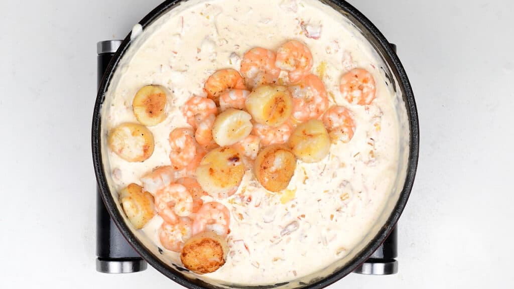 Scallops and shrimp cooking in a creamy sauce