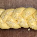 Topping braided tsoureki dough with flaked almonds
