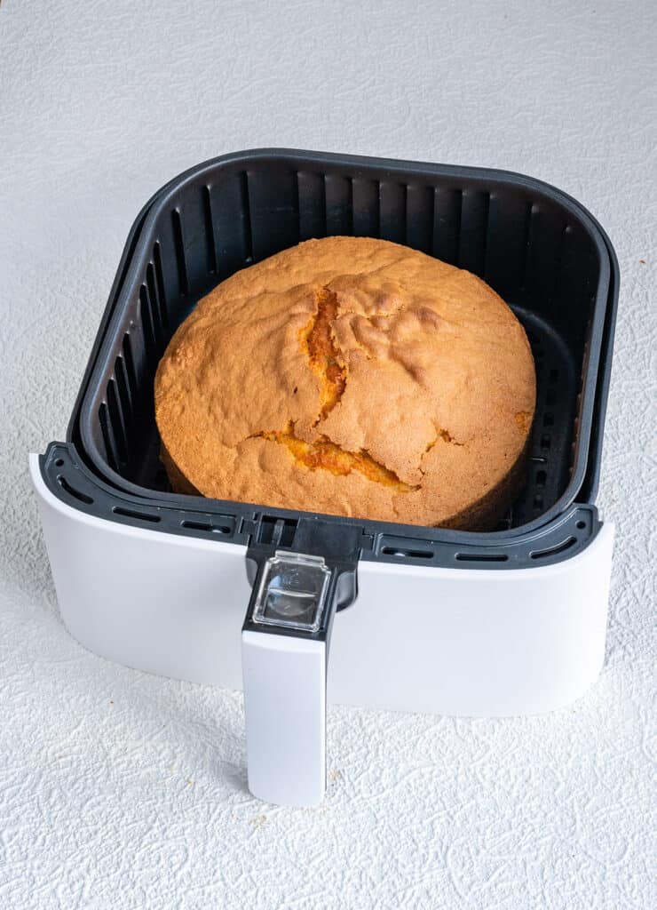 Air fryer with a sponge cake in the basket