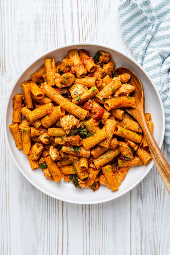 Large bowl of chicken and chorizo pasta in tomato sauce