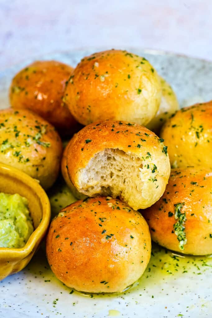 close up on garlic dough balls, one with bite taken out