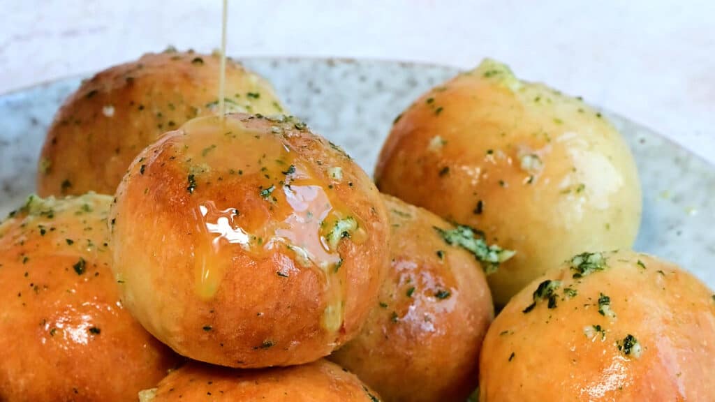 close up on dough balls with garlic butter drizzle