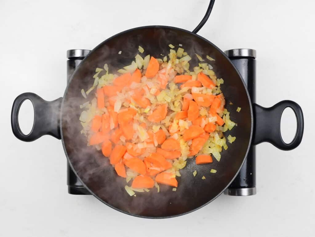 cooking onions and carrots in a pan