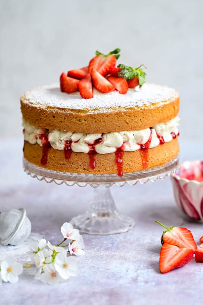 Victoria sponge Cake with buttercream made using Mary Berry's all-in-one recipe on a cake stand 