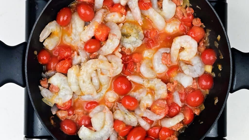 prawns cooking with fresh tomatoes in a pan