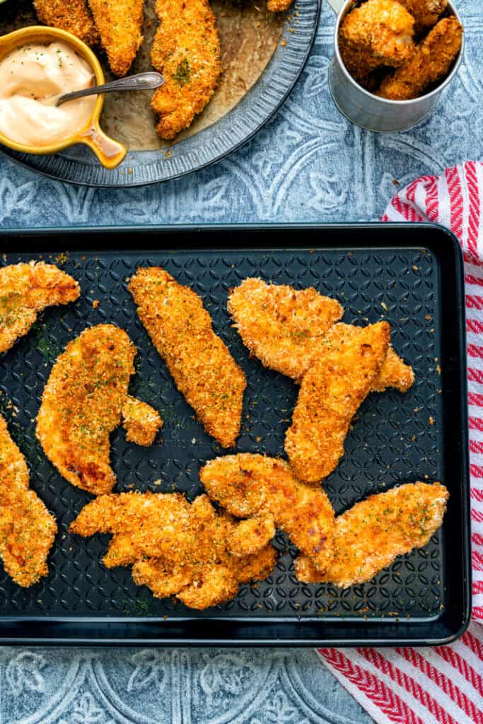 Crispy chicken goujons on a baking tray