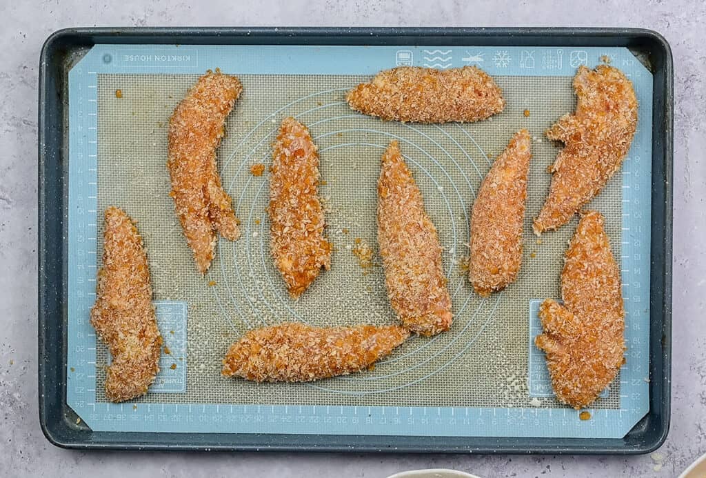 chicken strips spaced out on baking tray