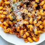slow cooker bolognese sauce served with spiral pasta in a white bowl