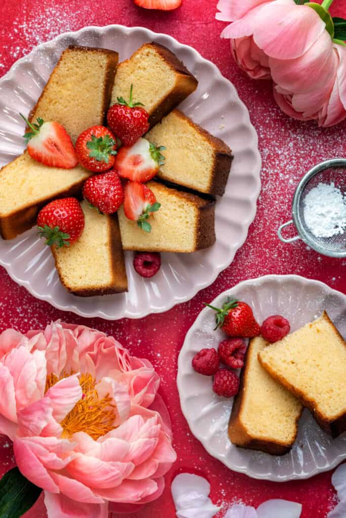 Condensed milk cake sliced on two plates with fresh berries