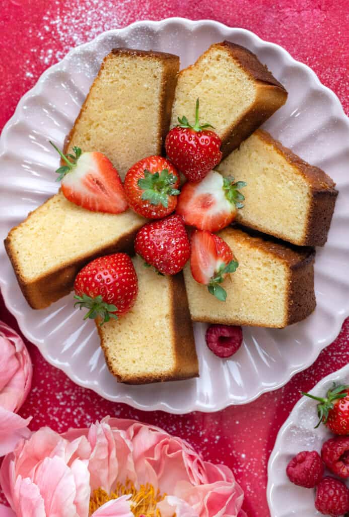 sliced condensed milk pound cake on a scalloped plate