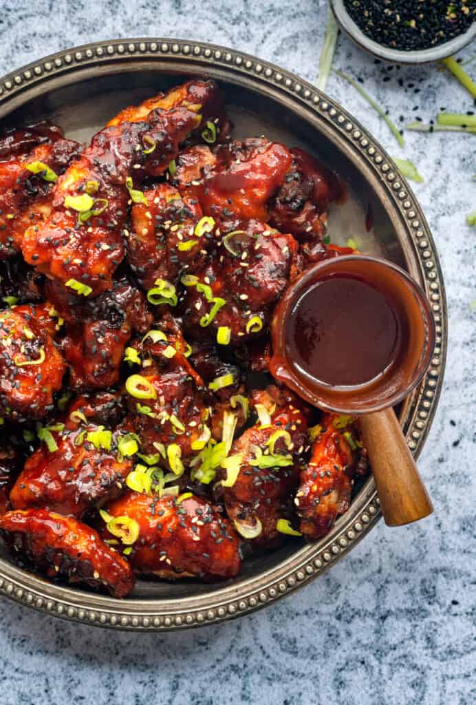Bowl of Korean Fried Chicken in a sweet-spicy chilli sauce garnished with sesame seeds