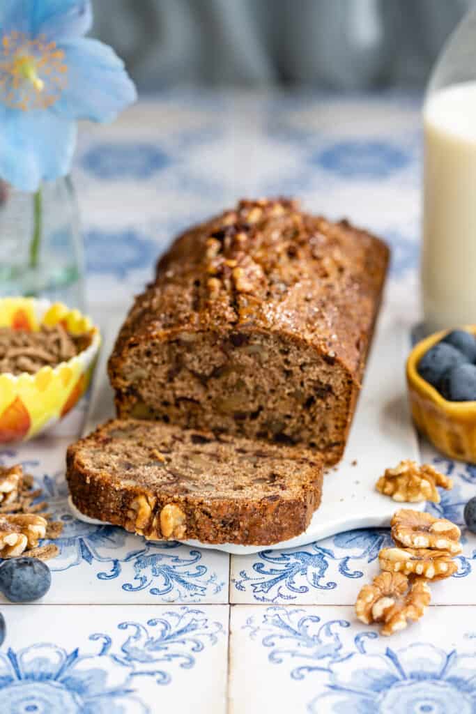 Bran Loaf with dried fruit and nuts on a ceramic board with slice cut