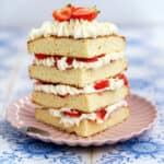 Sponge cake slice layered with fresh cream and strawberries