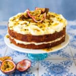 Passion Fruit cake on a cake stand decorated with syrup and fresh passionfruit