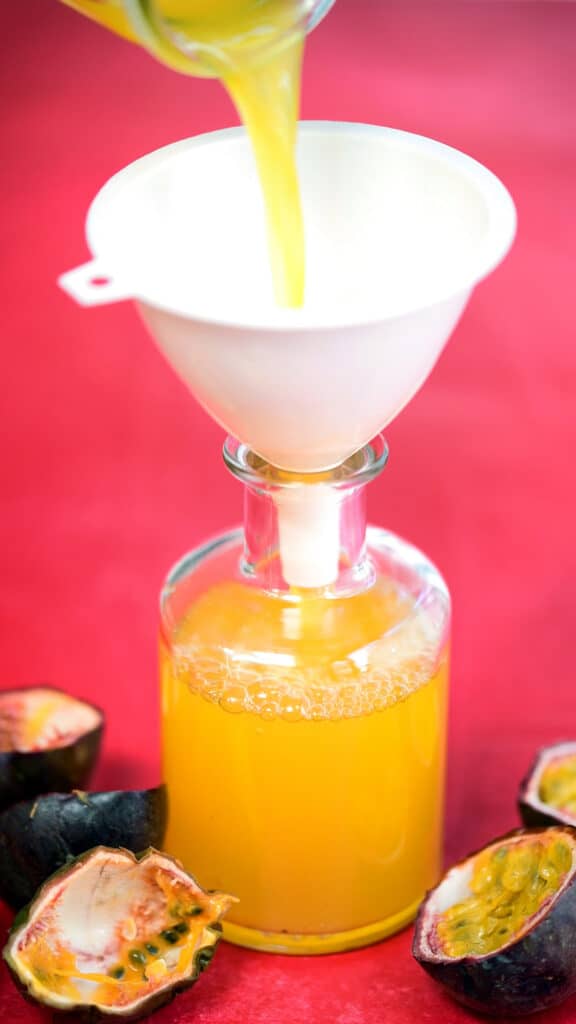 decanting passion fruit syrup into a small bottle