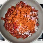 Pan frying chorizo, shallots with Cajun seasoning