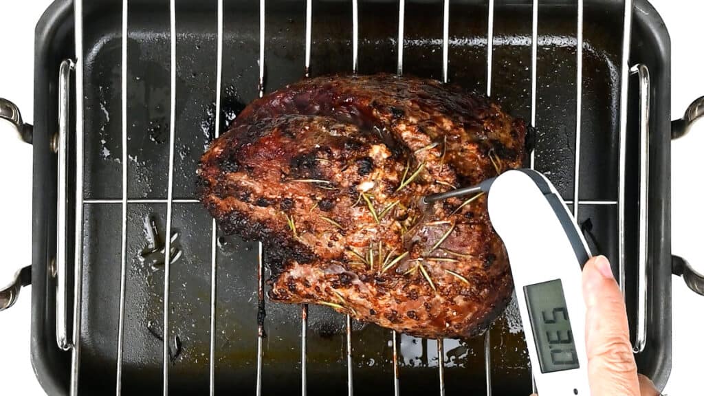 Checking the temperature of beef joint with digital thermometer 