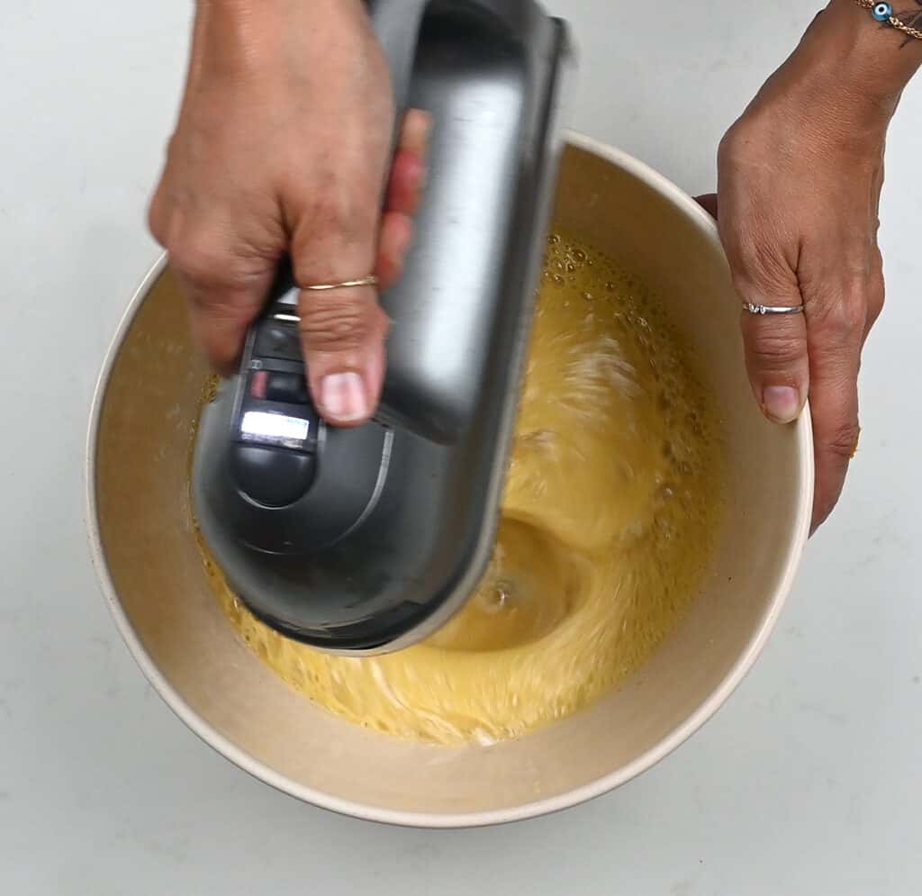 Beating eggs and sugar in a mixing bowl