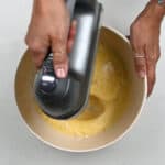 Beating eggs and sugar in a mixing bowl
