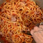 tossing pasta with tomato sauce