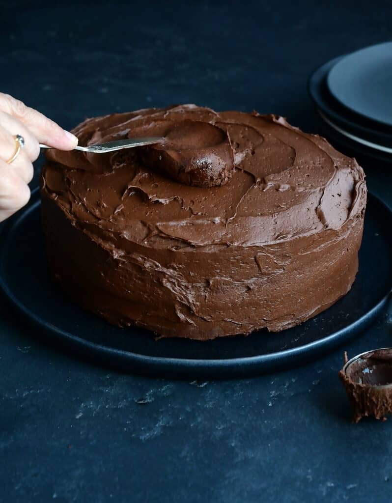 Frosting a chocolate cake