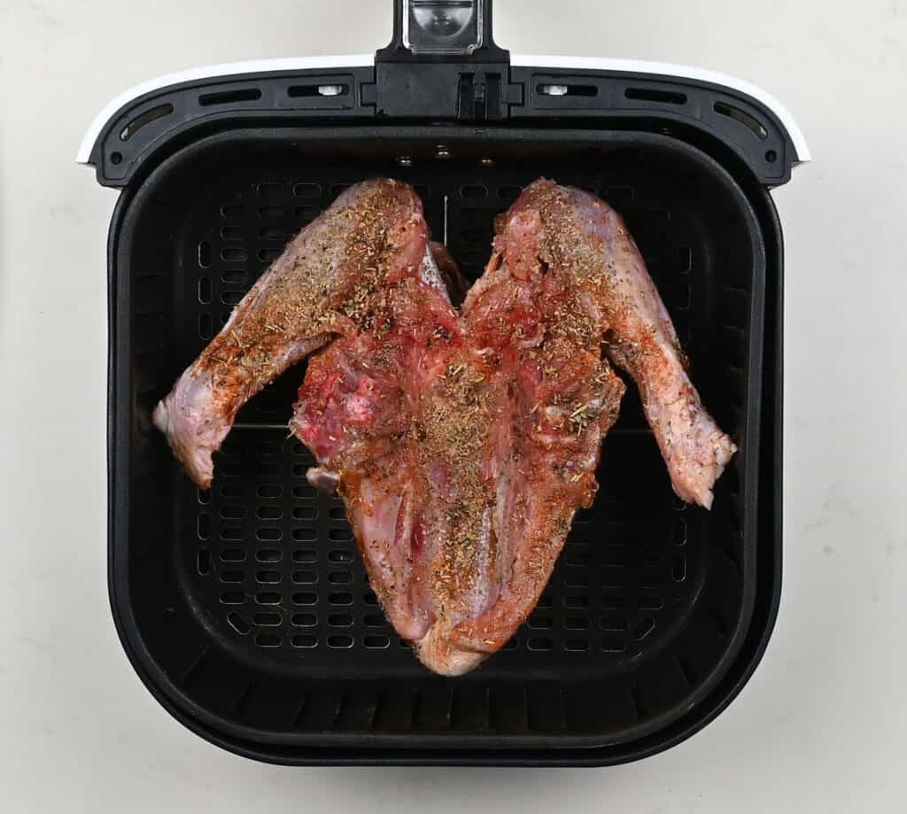 turkey breast, skin side down, in an air fryer basket