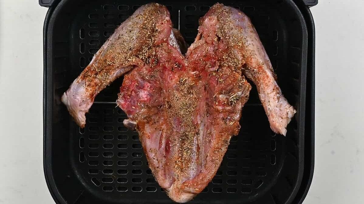 turkey breast, skin side down, in an air fryer basket