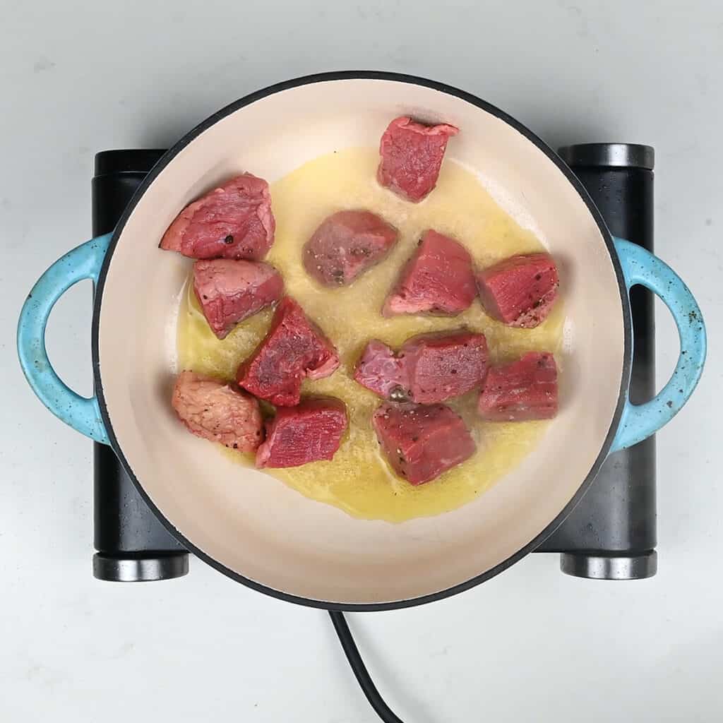 browning beef cubes in a Dutch Oven
