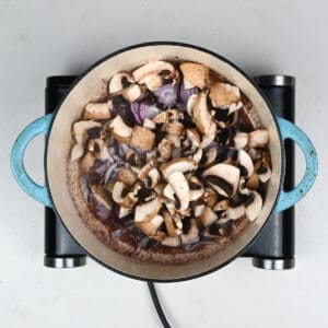 mushrooms and onions cooking in a pot