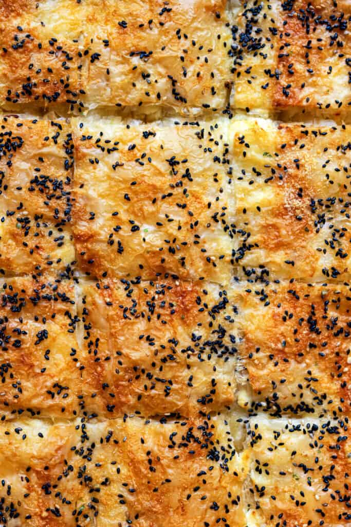 Close up on tyropita topped with sesame seeds