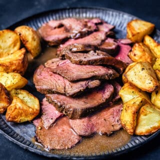 Sliced roast venison with gravy and potatoes
