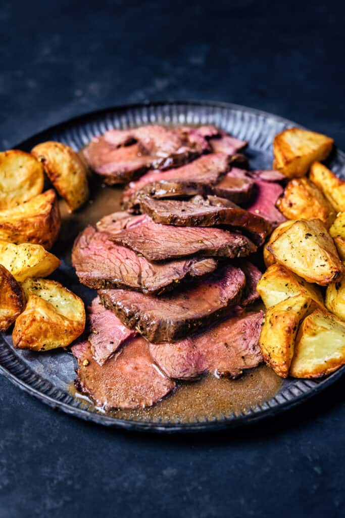 Sliced roast venison with gravy and potatoes