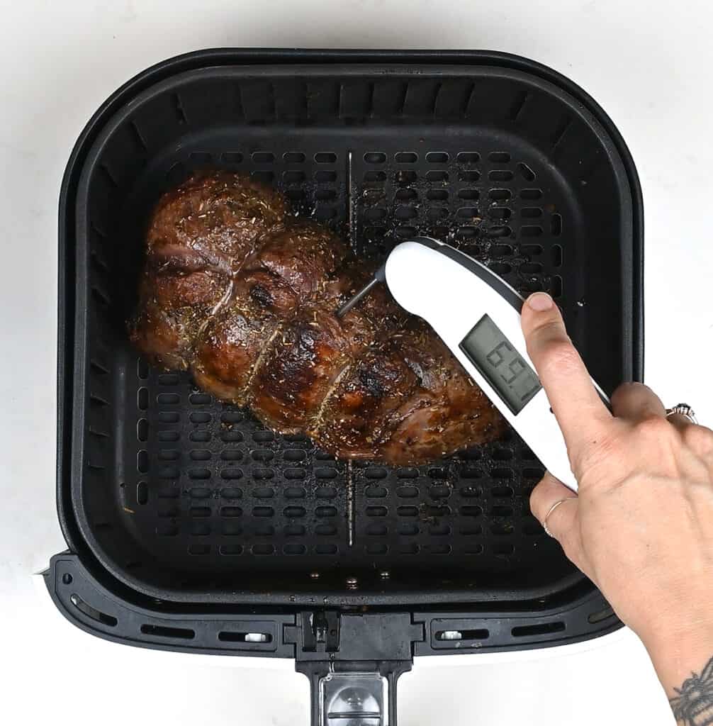 checking the temperature of  air fryerroast venison with a meat thermometer