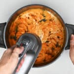 whipping sweet potatoes in a pot with an electric hand mixer